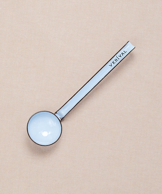 Elegant ruht ein blauer, runder Emaille-Schöpflöffel von Riess auf beigem Untergrund. Sein langer Griff trägt die Aufschrift der Marke Riess – ein exquisites Werkzeug zum präzisen Portionieren.