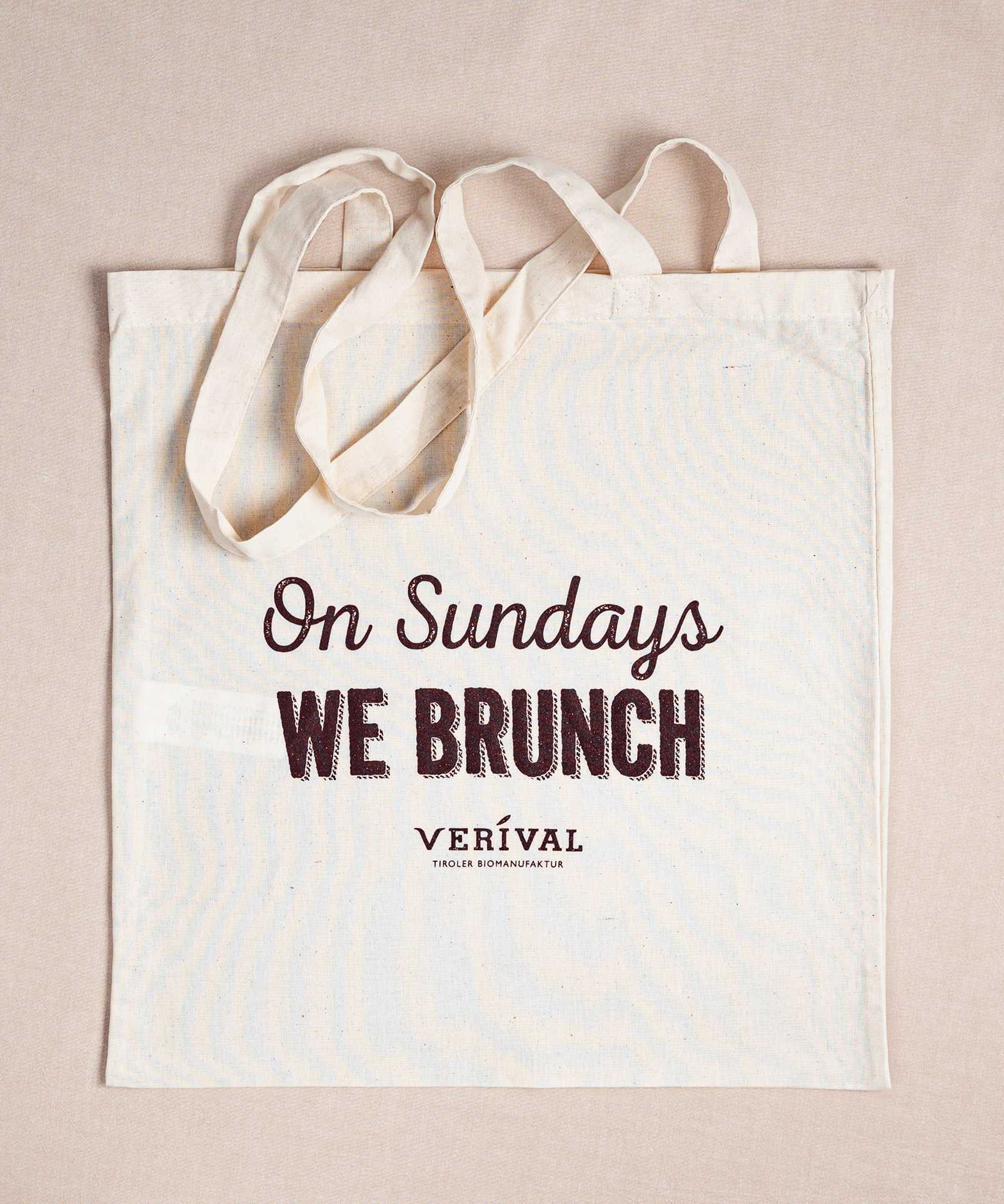 Die Verival Bio Stofftasche ist eine beigefarbene Tragetasche aus Bio-Baumwolle mit dem auffälligen Schriftzug „On Sundays we brunch“ und dem dezenten Schriftzug "Verival" darunter. Perfekt zum Einkaufen, mit zwei langen Henkeln für bequemes Tragen.