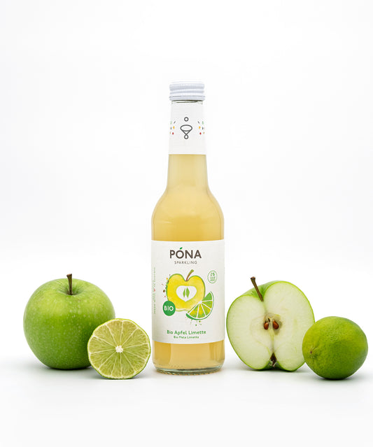 Eine Flasche PONA Apfel-Limette der Wonderful Biodrinks GmbH ist auf weißem Hintergrund abgebildet, umgeben von einem Apfel, einem halbierten grünen Apfel, einer Limette und einer Limettenhälfte. 