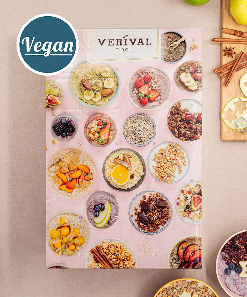 Die Adventskalender-Box Vegan von Verival Bio, verziert mit Abbildungen köstlicher Gerichte aus Früchten, Nüssen und Getreide sowie einem prominenten Vegan-Label, ist ideal für eine gesundheitsbewusste Morgenroutine.