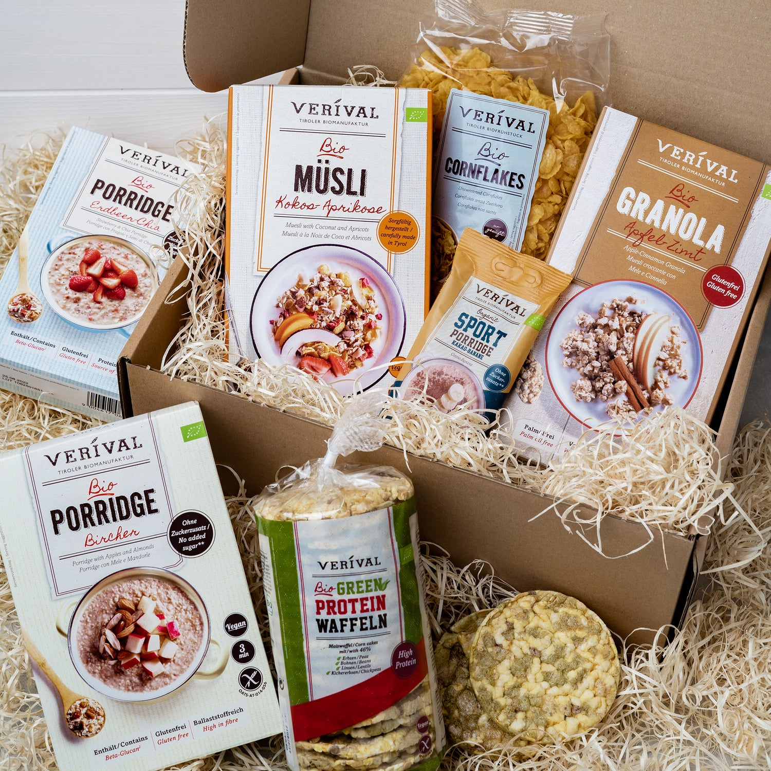 Viele Verival Frühstücksprodukte in einer Geschenkset-Box auf Holzwolle.
